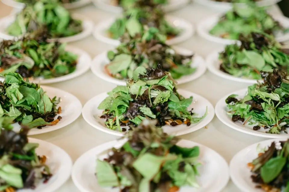 Several plates of fresh mixed salad greens arranged on a table, each dish garnished with assorted leafy greens. The presentation is uniform, highlighting the vibrant colors and textures of the greenery. 124 on Queen Hotel and Spa | Hotel & Spa Niagara-on-the-lake | 1 (855) 988-4552
